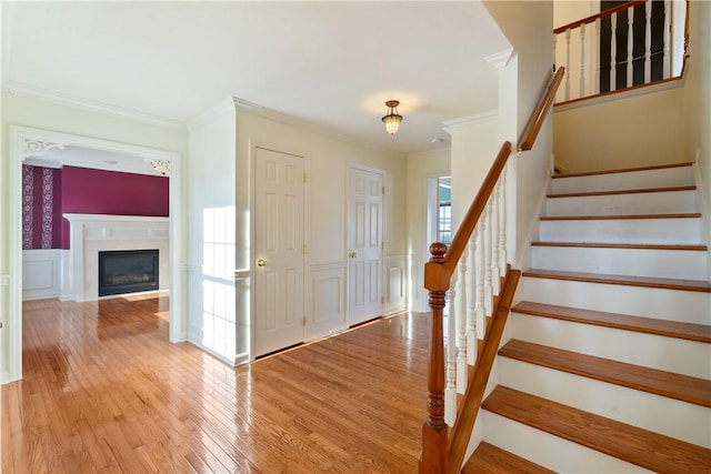 entrance foyer featuring light wood-type flooring and ornamental molding