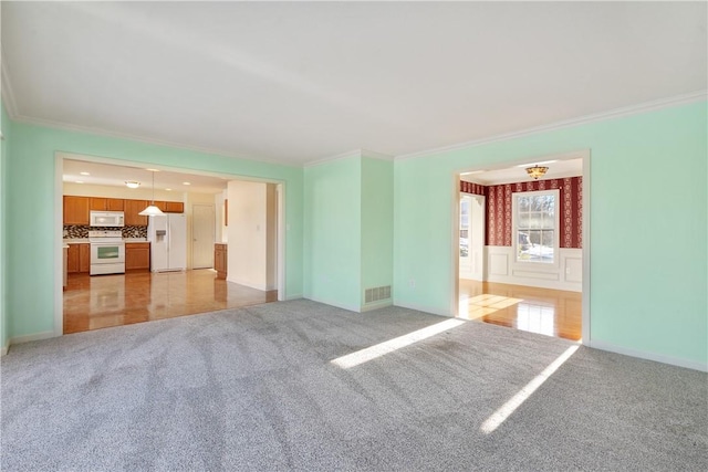 unfurnished living room featuring light colored carpet and ornamental molding