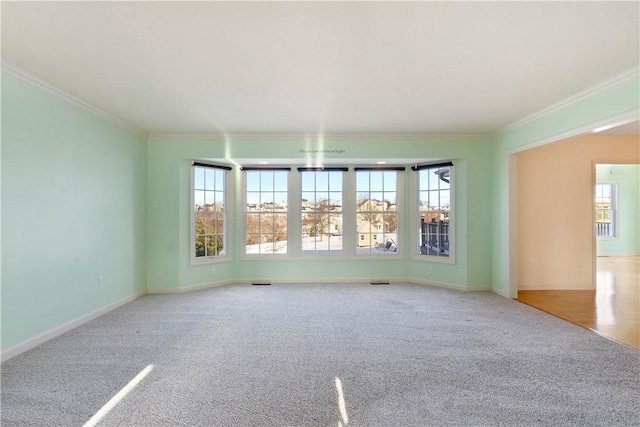 unfurnished room with light colored carpet, ornamental molding, and a wealth of natural light