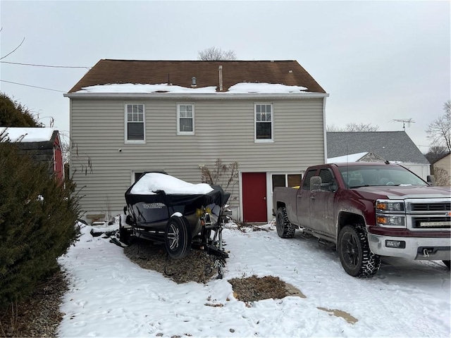 view of snow covered back of property