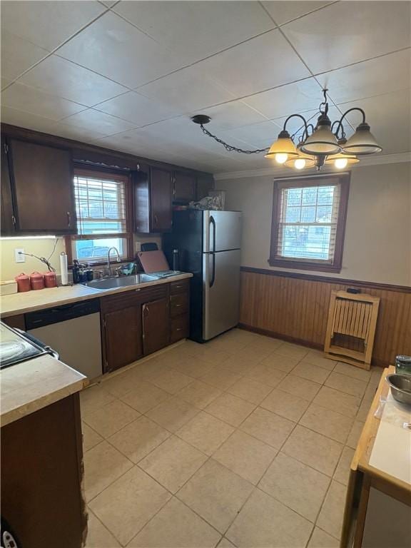 kitchen with stainless steel refrigerator, a healthy amount of sunlight, ornamental molding, and sink