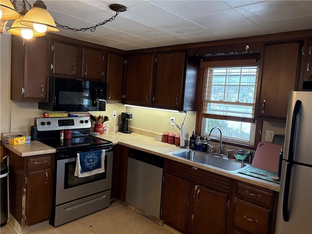 kitchen featuring hanging light fixtures, appliances with stainless steel finishes, sink, and dark brown cabinetry