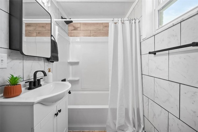 bathroom with decorative backsplash, shower / bath combo with shower curtain, vanity, and tile walls