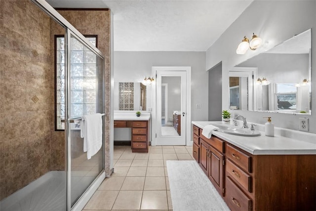 bathroom featuring tile patterned floors, vanity, and a shower with shower door