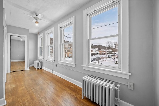 interior space with radiator and ceiling fan