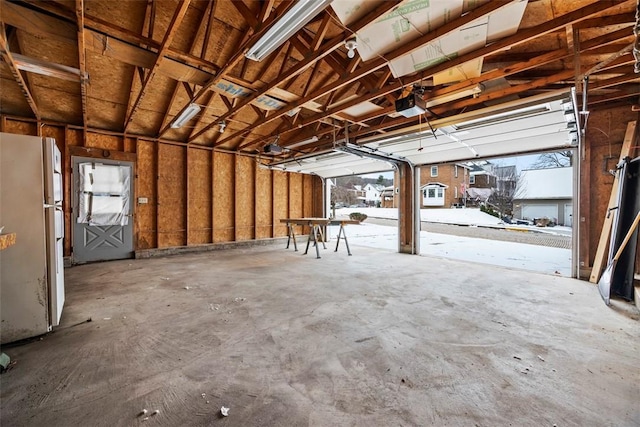 garage featuring a garage door opener and white refrigerator