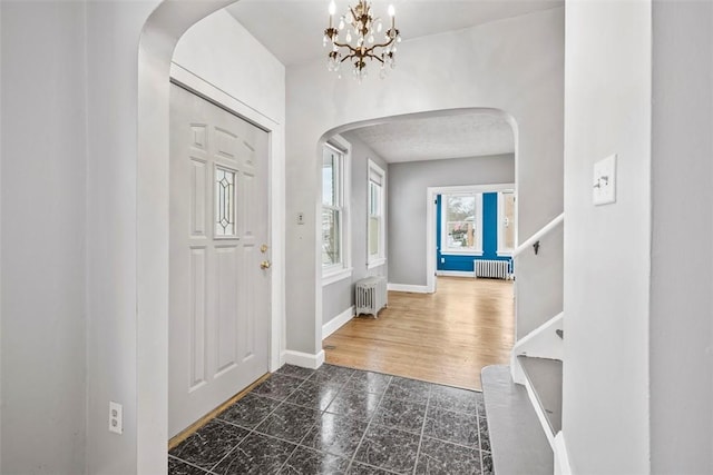 entryway featuring an inviting chandelier and radiator