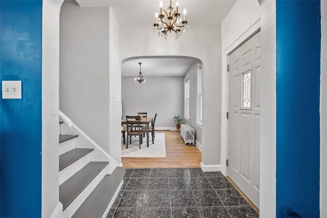 foyer featuring a notable chandelier, dark hardwood / wood-style flooring, and radiator heating unit