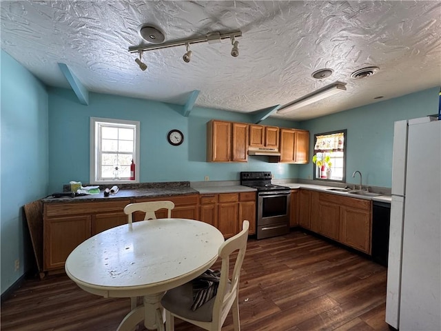 kitchen with dark wood-type flooring, track lighting, sink, electric range, and white fridge