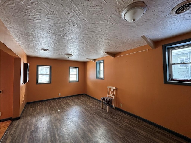 unfurnished room featuring a textured ceiling and dark wood-type flooring