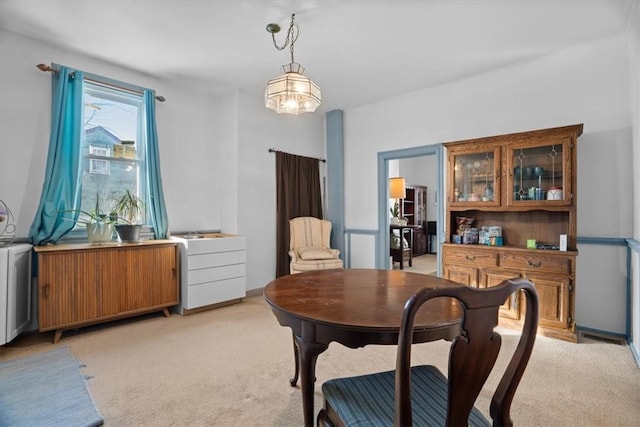 carpeted dining area with a notable chandelier