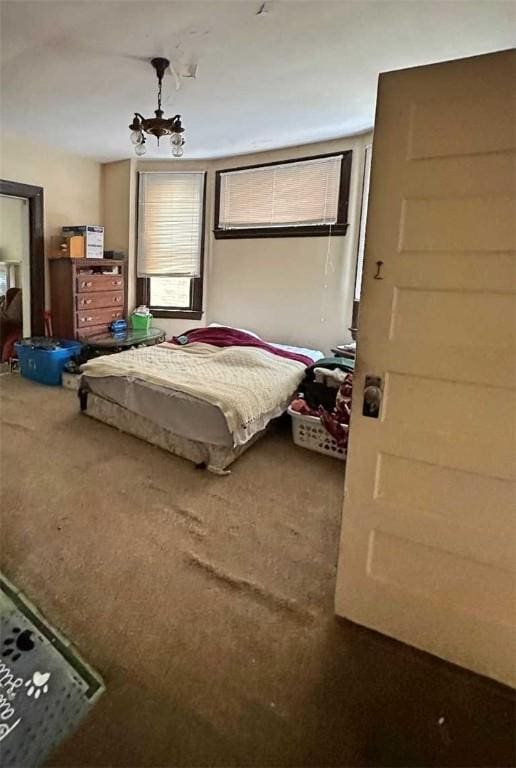 carpeted bedroom featuring a notable chandelier