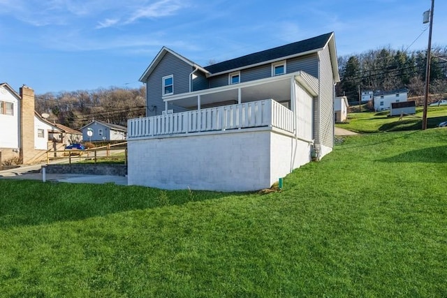 rear view of house featuring a yard and a balcony