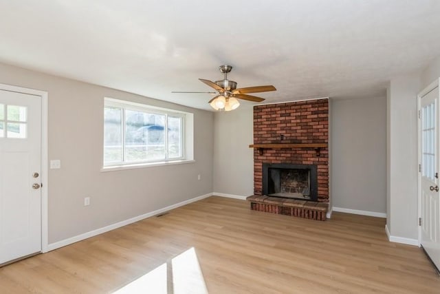 unfurnished living room with ceiling fan, a fireplace, and light hardwood / wood-style flooring