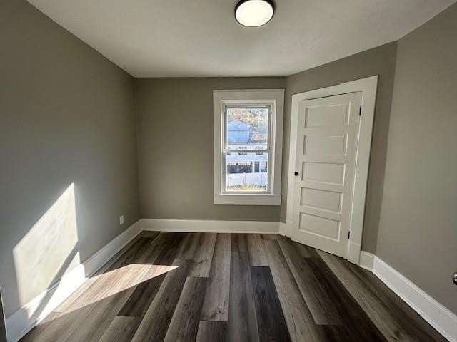 unfurnished room with dark hardwood / wood-style floors