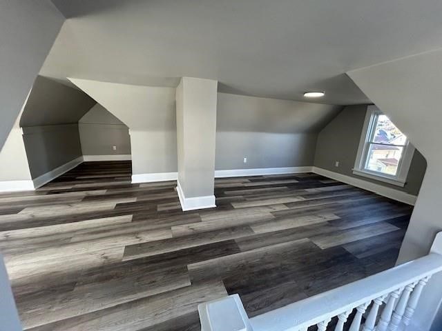 additional living space with dark wood-type flooring and lofted ceiling