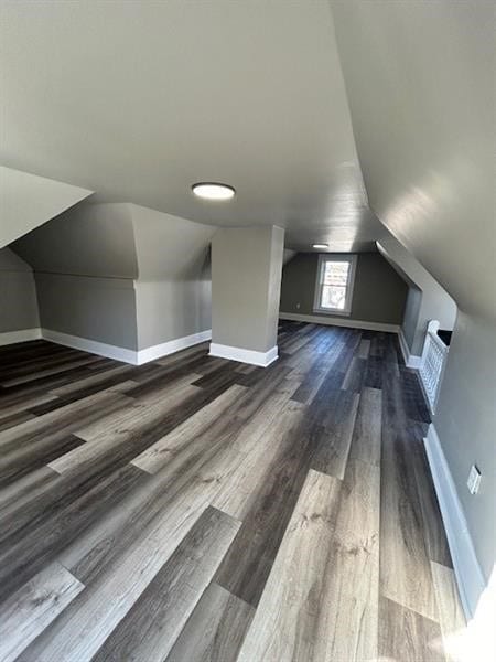 bonus room featuring dark hardwood / wood-style floors and vaulted ceiling