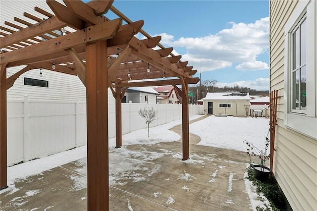 snow covered patio with a pergola and an outdoor structure