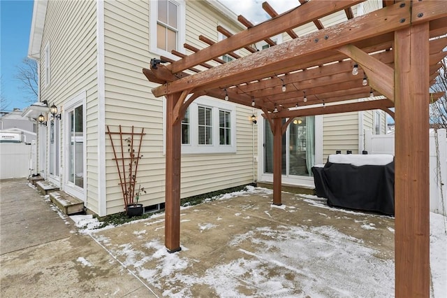 snow covered patio featuring a pergola and a grill