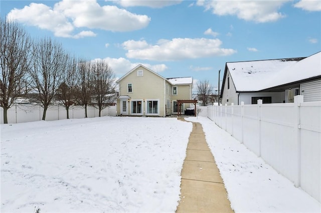 view of snow covered back of property