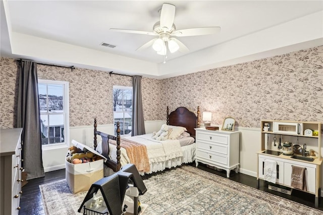 bedroom featuring a tray ceiling, ceiling fan, and dark hardwood / wood-style floors