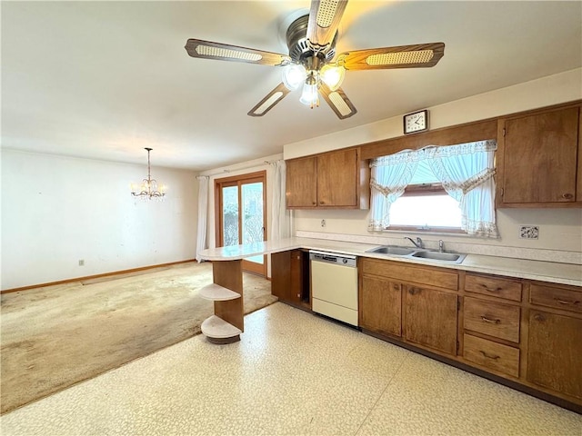 kitchen featuring white dishwasher, ceiling fan with notable chandelier, sink, a wealth of natural light, and decorative light fixtures