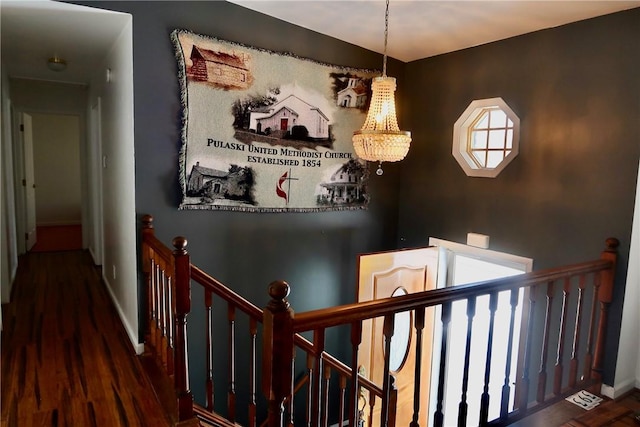 hallway featuring dark wood-type flooring and a notable chandelier