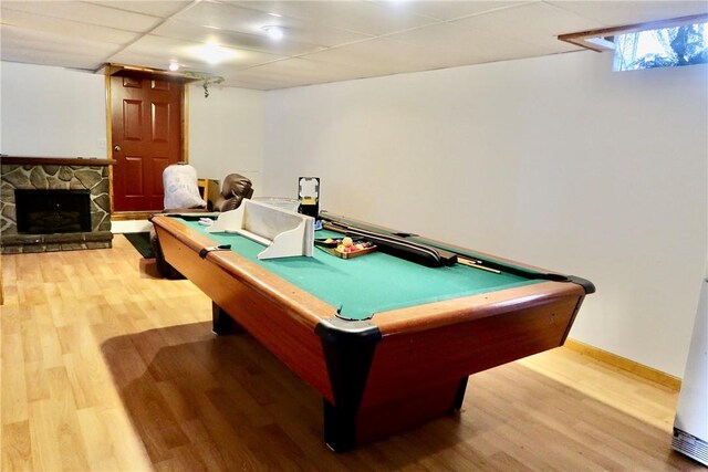 recreation room with hardwood / wood-style flooring, a drop ceiling, a fireplace, and pool table