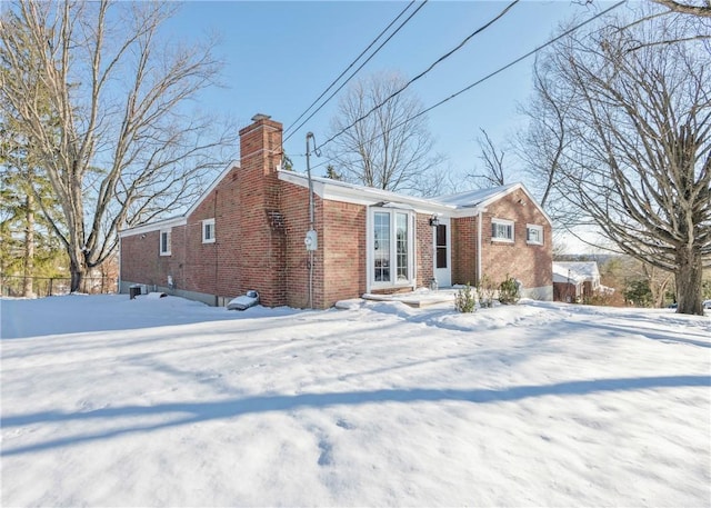 view of snow covered back of property