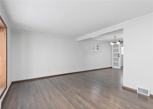 unfurnished living room with ornamental molding, visible vents, wood finished floors, and baseboards