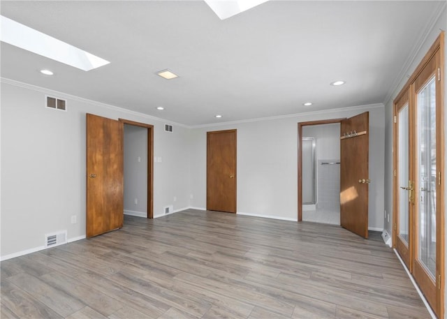 interior space with light wood-style floors, visible vents, recessed lighting, and a skylight