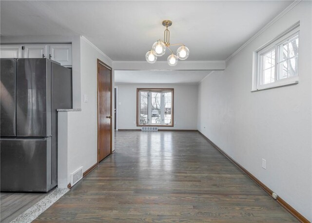 unfurnished dining area featuring visible vents, ornamental molding, an inviting chandelier, and plenty of natural light