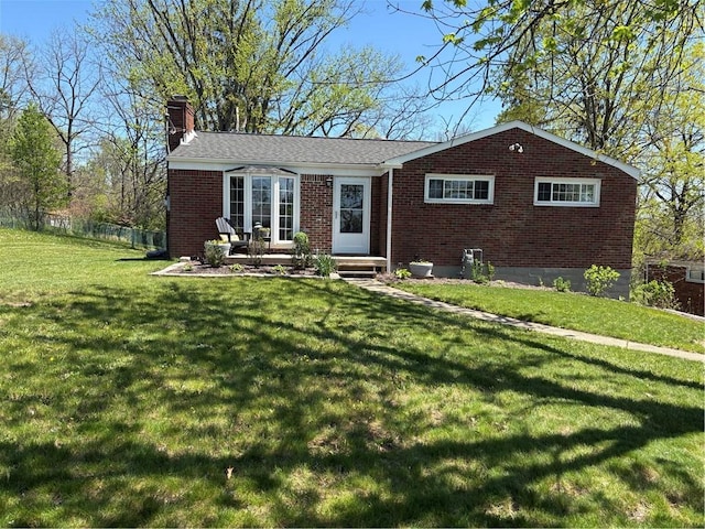 single story home featuring a chimney, brick siding, fence, and a front yard