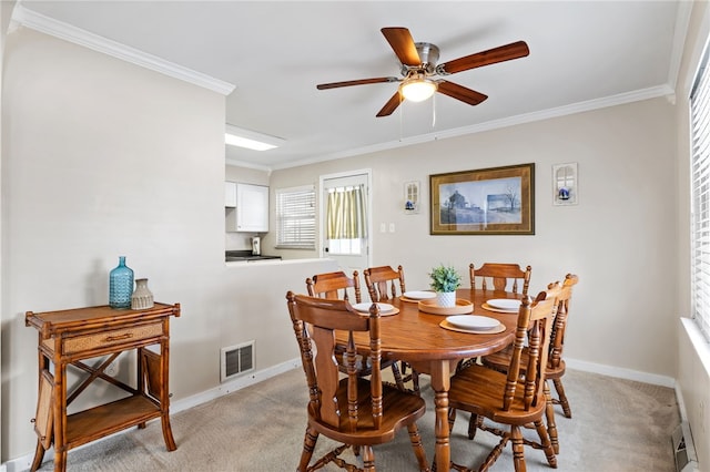 carpeted dining area featuring ceiling fan and crown molding