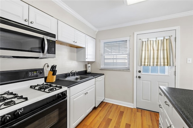 kitchen featuring sink, a healthy amount of sunlight, crown molding, white appliances, and white cabinets