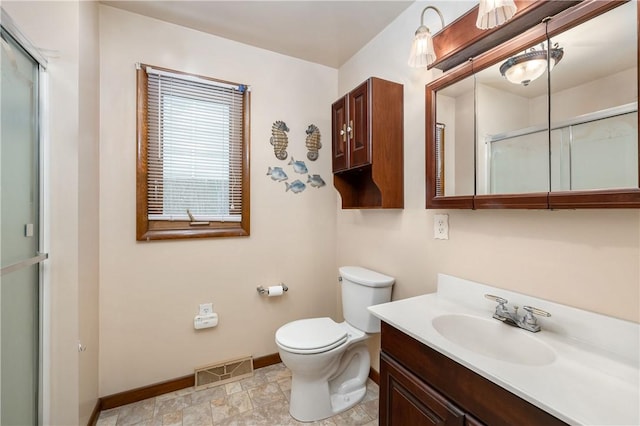 bathroom featuring toilet, vanity, and walk in shower