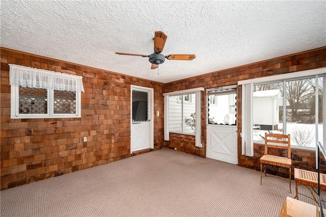 unfurnished sunroom with ceiling fan