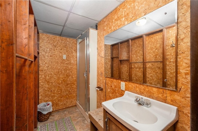 bathroom with a paneled ceiling, vanity, and a shower with shower door