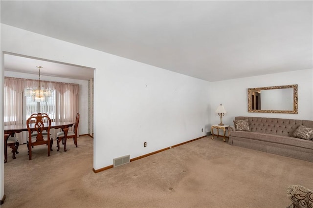 living room with carpet floors and a chandelier