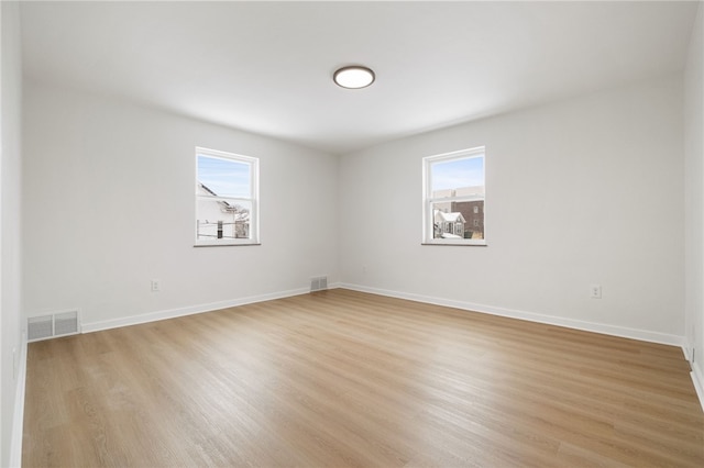 empty room featuring light hardwood / wood-style flooring and a wealth of natural light