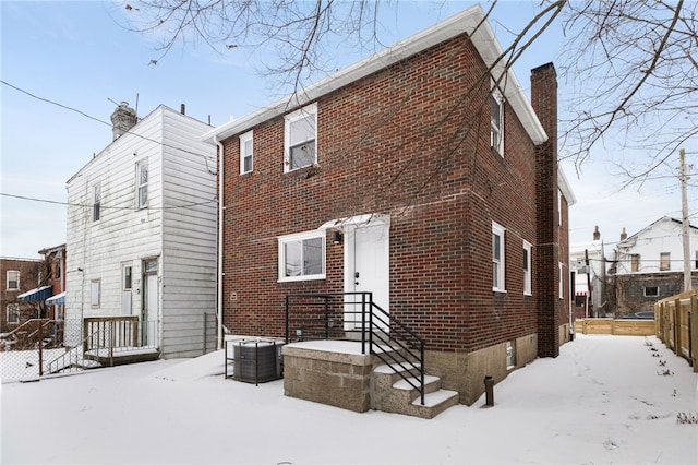 snow covered back of property with cooling unit