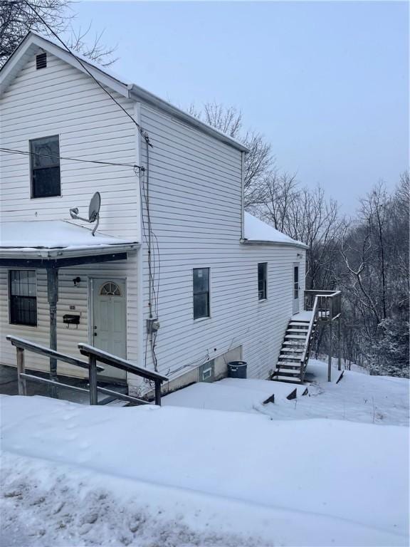 view of snow covered back of property