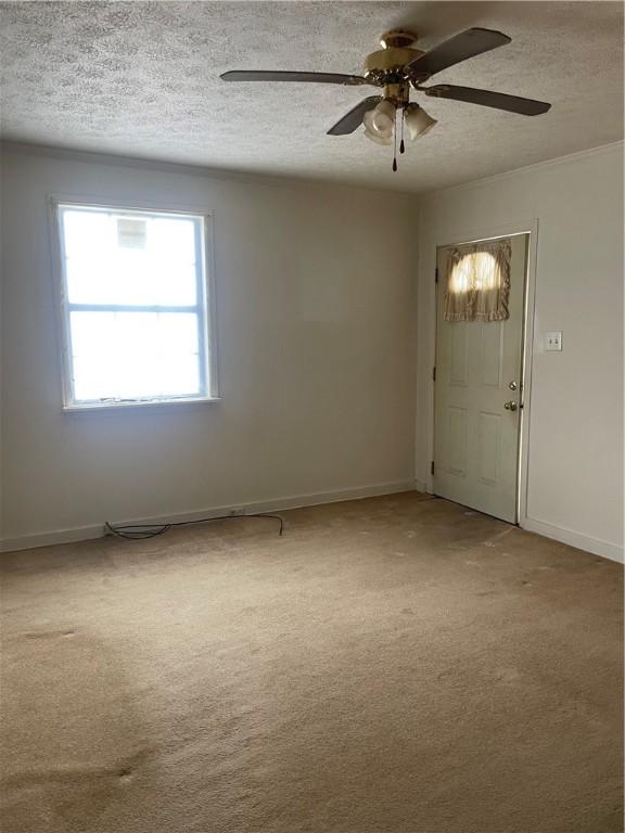 unfurnished room featuring carpet, a textured ceiling, and ceiling fan