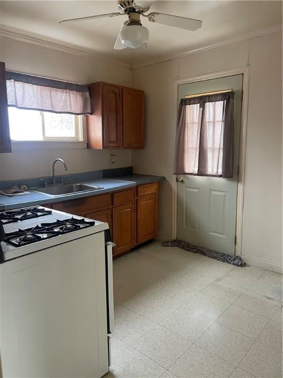 kitchen featuring ceiling fan, sink, white range with gas stovetop, and ornamental molding