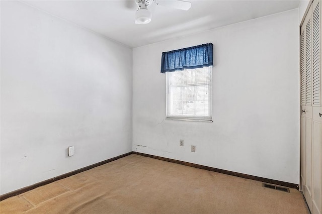 carpeted empty room featuring ceiling fan