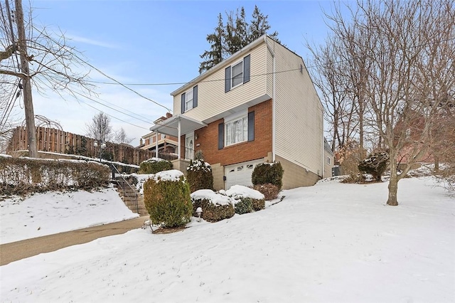 view of snow covered exterior featuring a garage