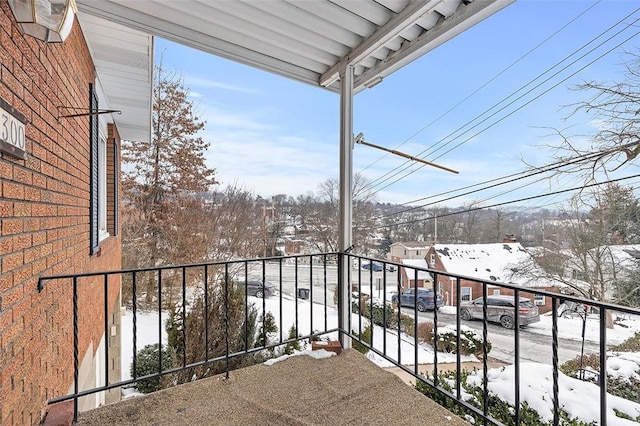 view of snow covered back of property