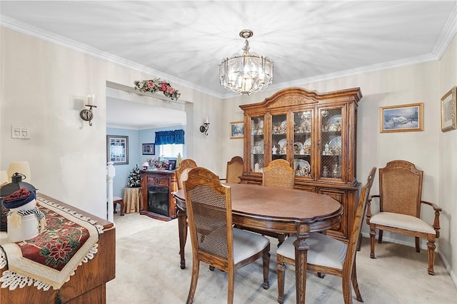 carpeted dining area featuring a chandelier and ornamental molding