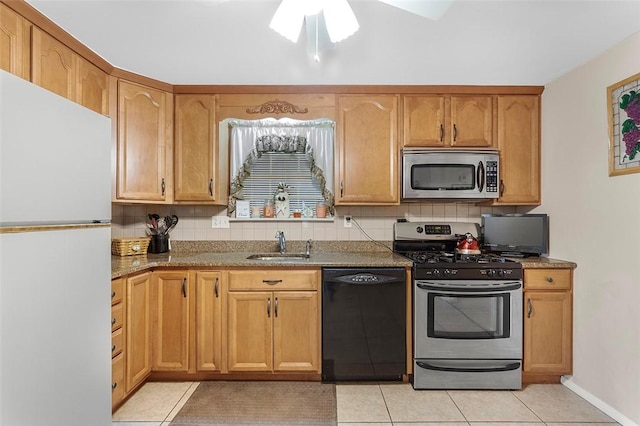 kitchen featuring light stone counters, stainless steel appliances, ceiling fan, sink, and light tile patterned floors