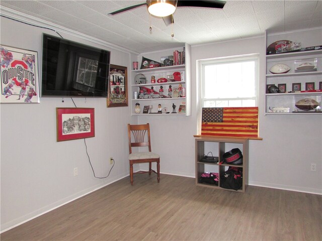 interior space featuring ceiling fan, ornamental molding, built in features, and hardwood / wood-style flooring